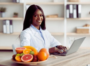 black woman with fruit and a computer for an online class